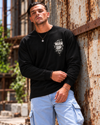 Model wearing black MUD BREAK THROUGH Monochrome Long Sleeve, front view with small monochrome Man Up Differently chest graphic