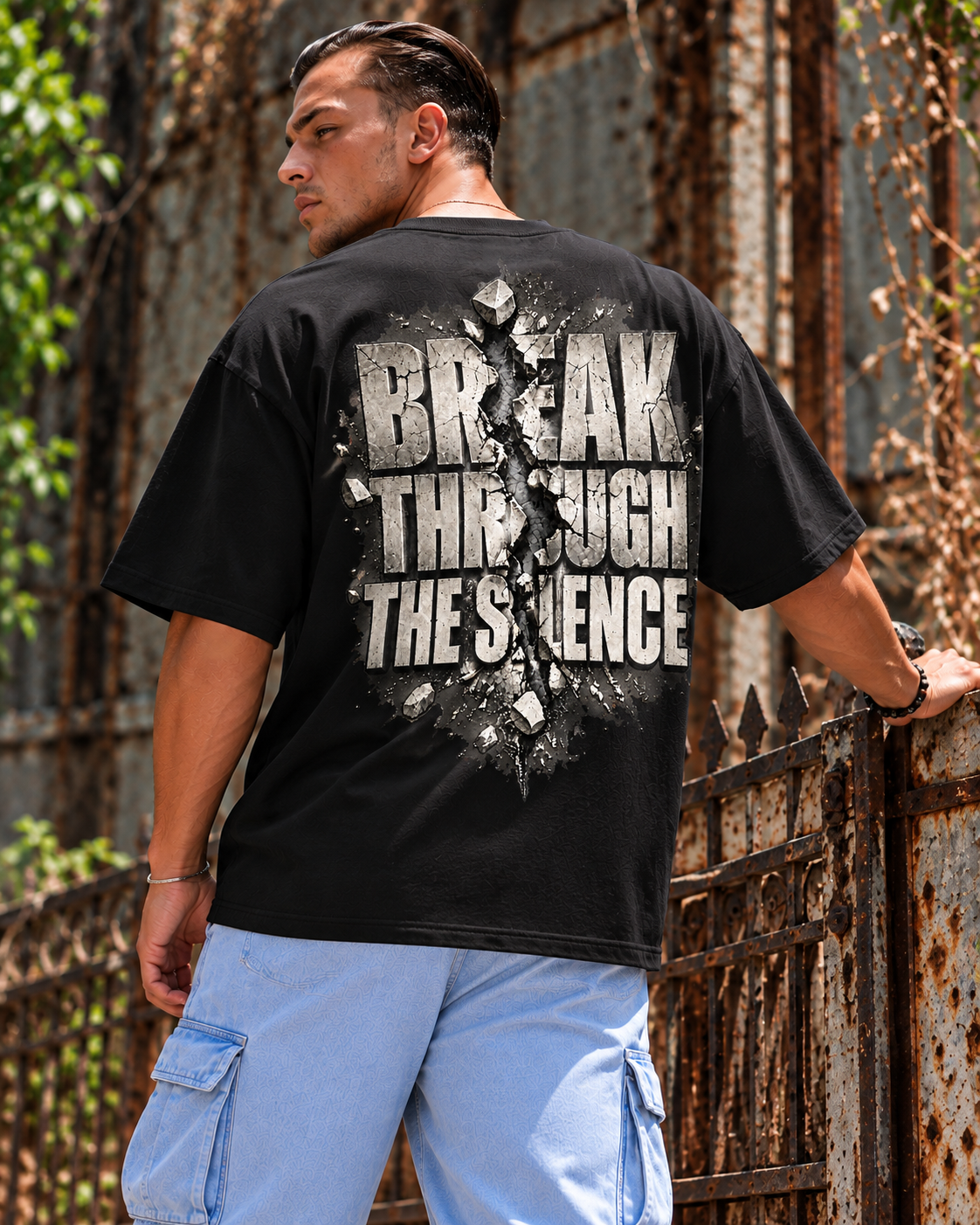 Model wearing black MUD BREAK THROUGH Monochrome Tee, back view with monochrome BREAK THROUGH THE SILENCE graphic