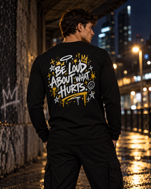 Model wearing black BE LOUD Long Sleeve back view with Be Loud About What Hurts print