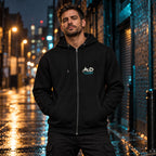 Man wearing the black MUD After Dark Zip Hoodie on a rainy city street at night, with the small MUD Man Up Differently logo on the left chest